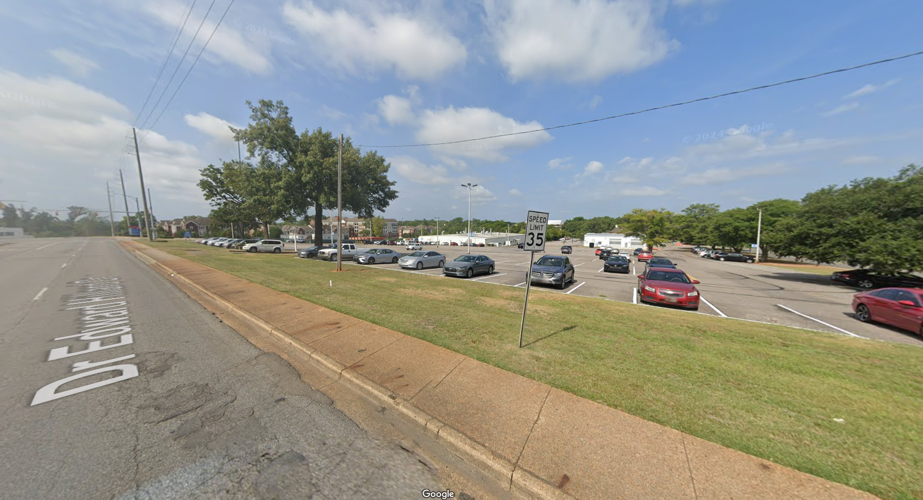DCH Employee Parking surface lot - recognizable features include apartment buildings in the background.